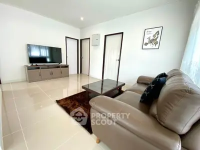 Modern living room with sleek furniture and wall-mounted TV, perfect for relaxation.