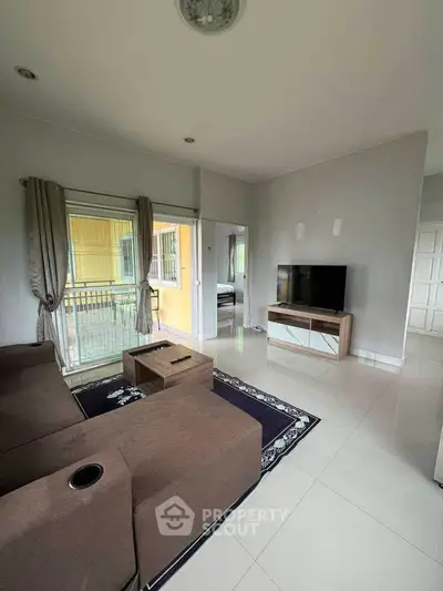 Modern living room with sleek furniture and large window for natural light.