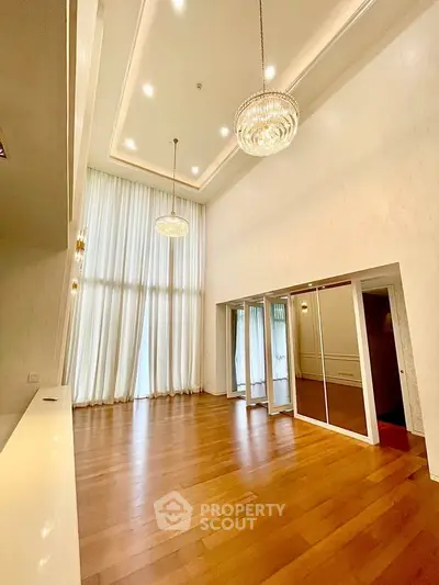 Spacious living room with high ceilings and elegant chandeliers in luxury apartment