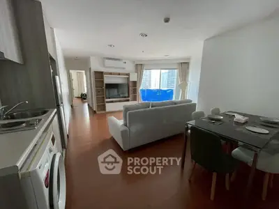 Spacious modern living room with open kitchen and dining area in a stylish apartment.