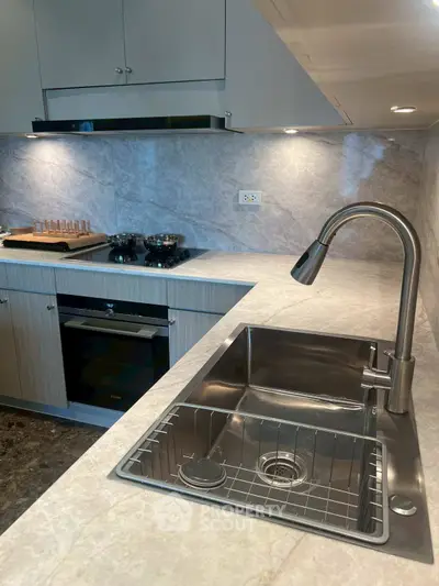 Modern kitchen with sleek stainless steel sink and built-in oven