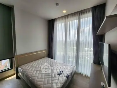 Modern bedroom with large window and natural light in high-rise apartment