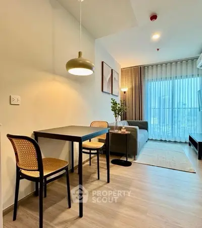 Modern living room with dining area, stylish decor, and large window for natural light.