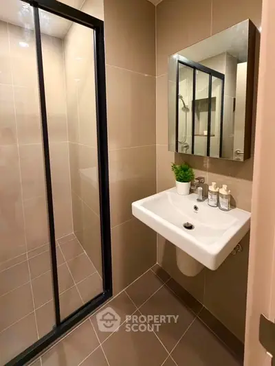 Modern bathroom with sleek shower and stylish sink in contemporary apartment.