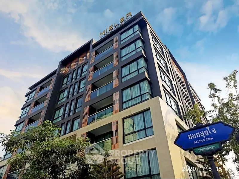 Modern urban apartment building with sleek design and large windows in vibrant city setting.