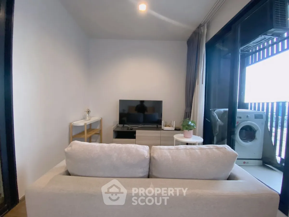 Cozy living room with modern decor and balcony view featuring washing machine.