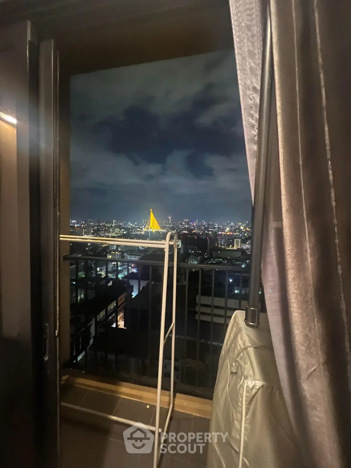 Stunning city view from a cozy balcony at night, perfect for urban living.
