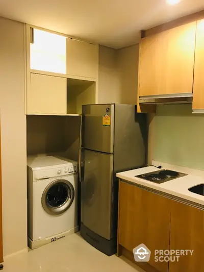 Modern kitchen with washing machine and fridge in compact layout