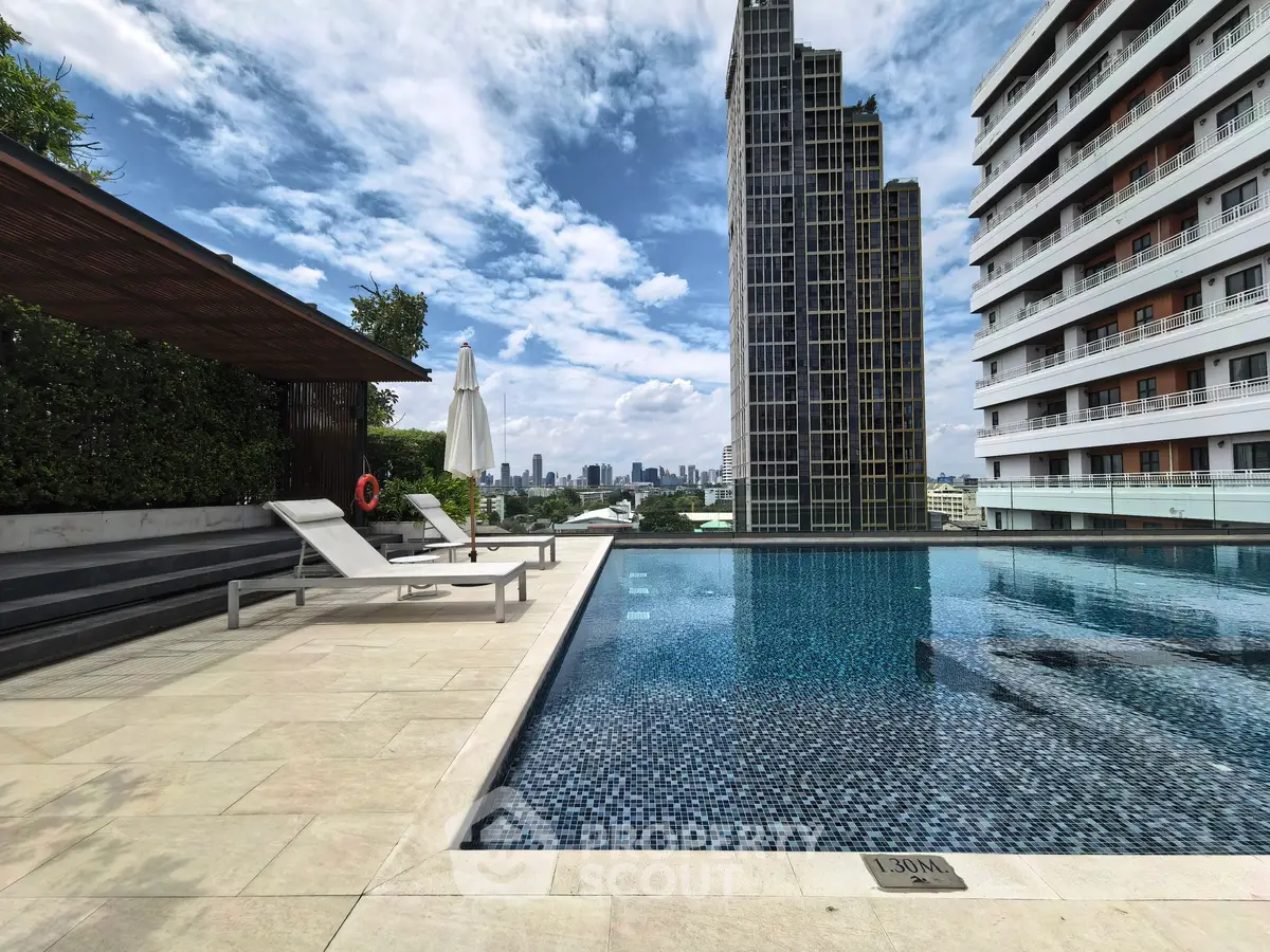 Luxurious rooftop pool with city skyline view in modern high-rise building.