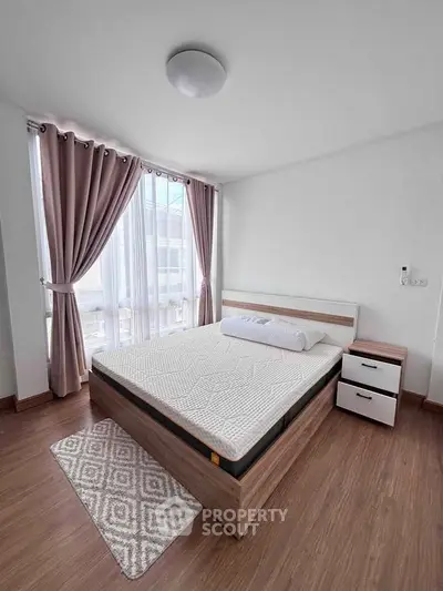 Spacious bedroom with large windows and modern furnishings, perfect for natural light lovers.