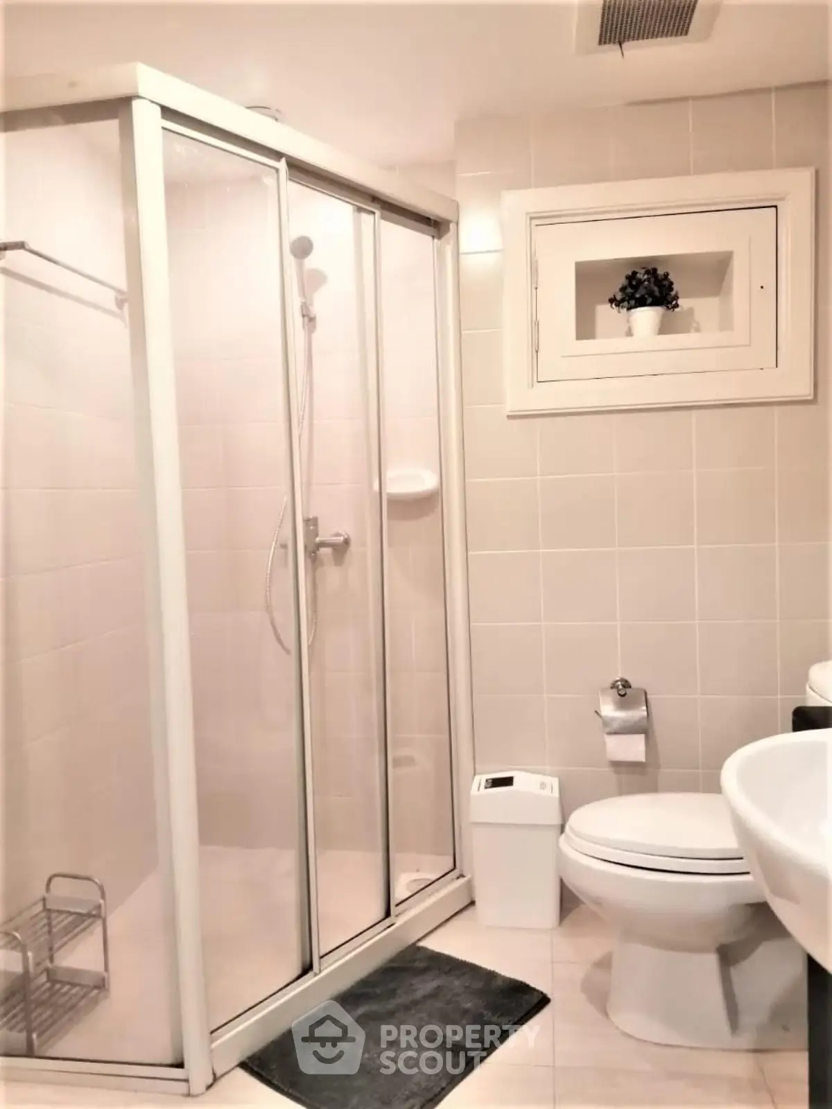 Modern bathroom with glass shower enclosure and sleek fixtures in a contemporary home.