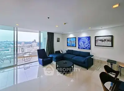 Spacious living room with modern decor and stunning city view from large balcony.