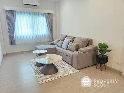 Modern living room with stylish sofa and coffee tables, featuring elegant curtains and a cozy atmosphere.