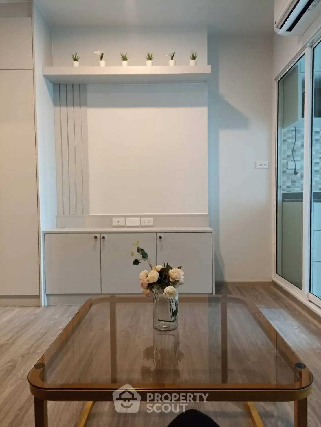 Modern living room with stylish decor and glass coffee table, perfect for contemporary living.