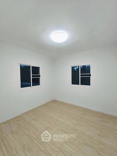 Spacious empty room with tiled flooring and bright lighting