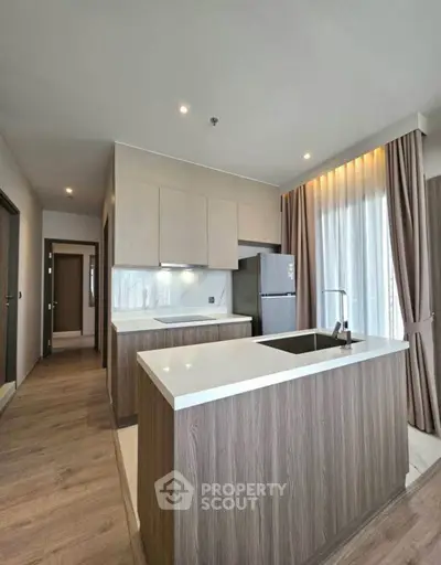 Modern kitchen with sleek island and natural light, perfect for culinary enthusiasts.
