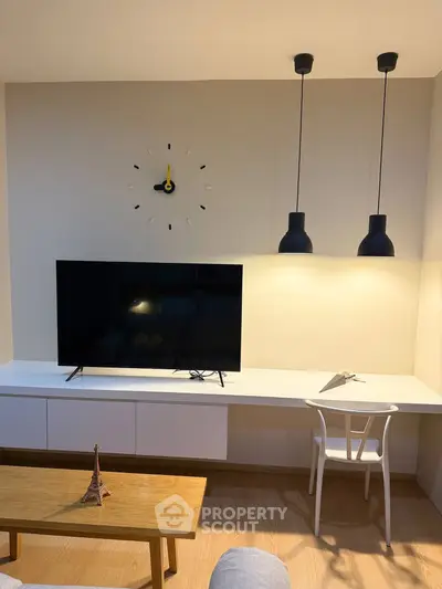 Modern living room with stylish TV setup and elegant lighting fixtures.