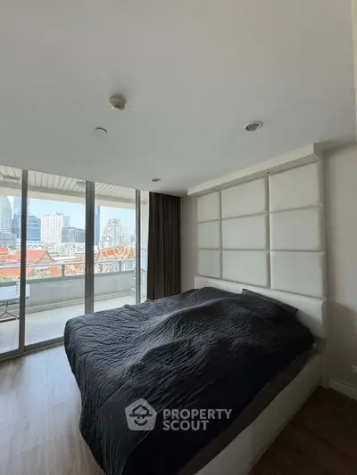 Spacious bedroom with city view and large windows in modern apartment