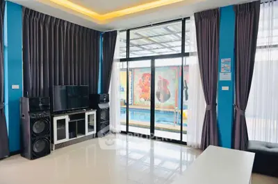 Spacious living room with modern entertainment setup and pool view, ideal for relaxation and gatherings.