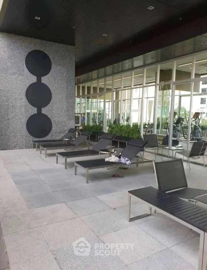 Luxurious poolside area with modern lounge chairs and stylish decor in a high-end residential complex.