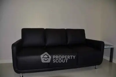 Modern black leather sofa in a minimalist living room setting