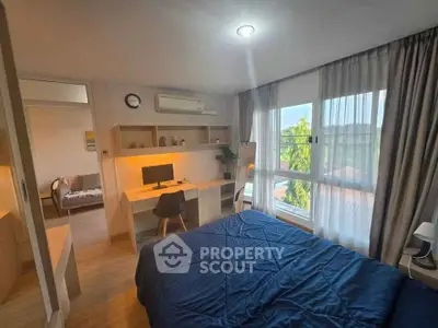 Modern bedroom with study area and large window offering natural light