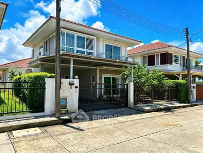 Charming two-story house with red-tiled roof and lush greenery in a serene neighborhood.
