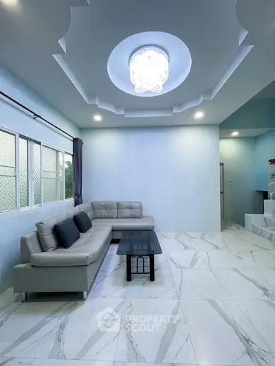 Spacious living room with modern decor and elegant ceiling design
