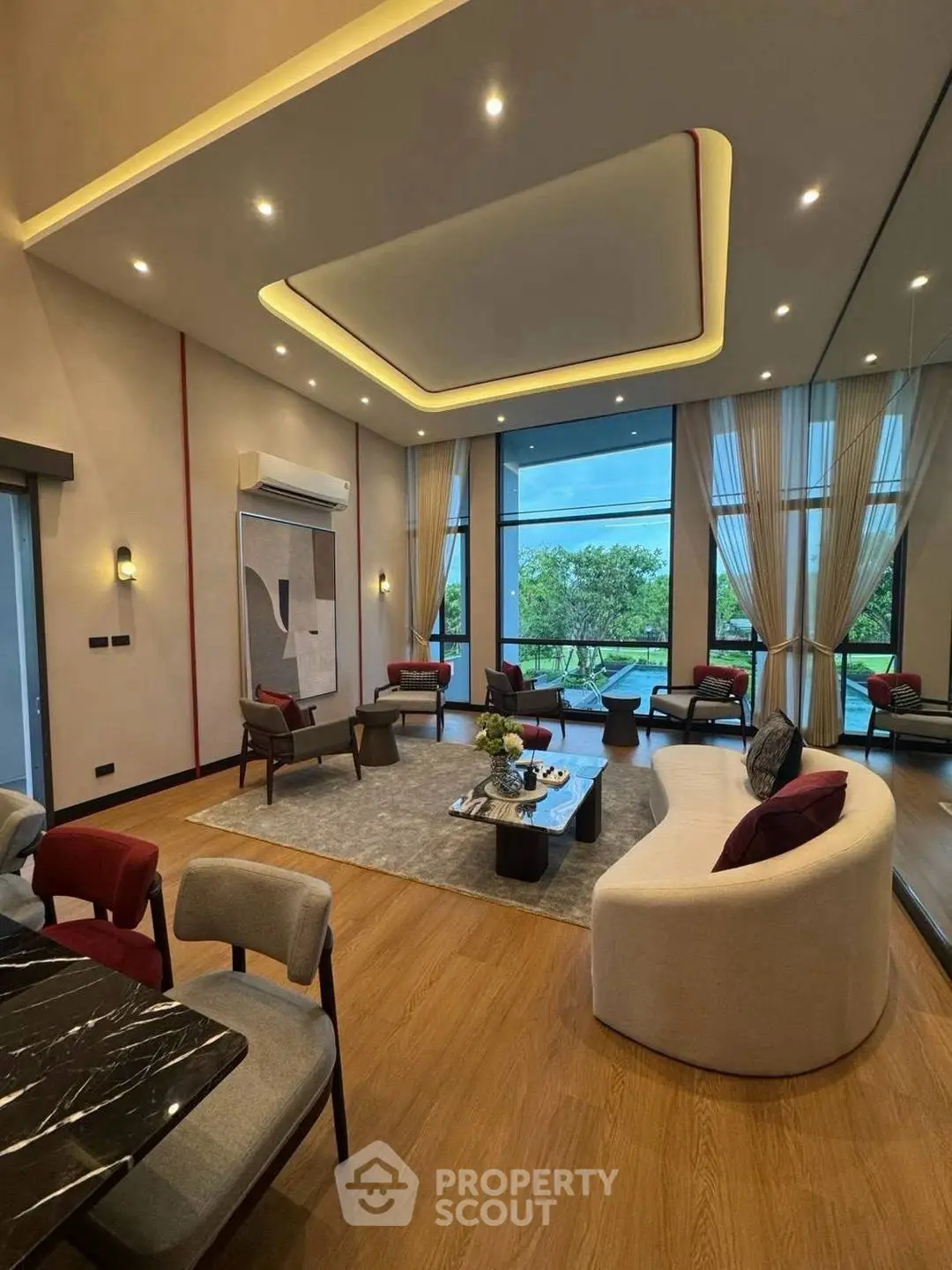 Luxurious modern living room with high ceilings and large windows offering stunning views.