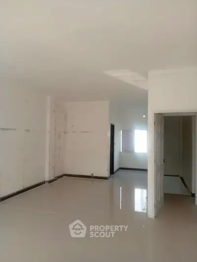 Spacious empty room with white walls and tiled floor, ready for customization.