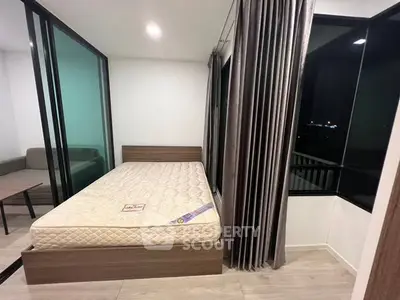 Modern bedroom with large windows and sleek design, featuring a comfortable bed and stylish curtains.