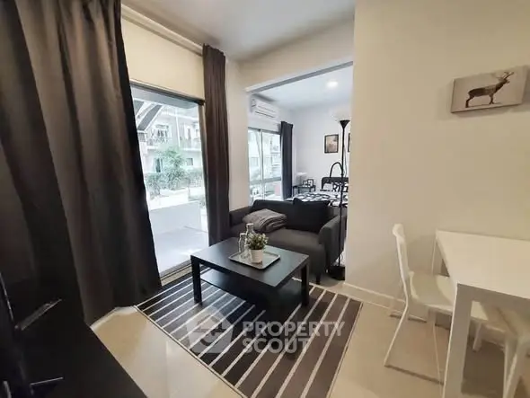 Modern living room with stylish decor and balcony view in a cozy apartment.
