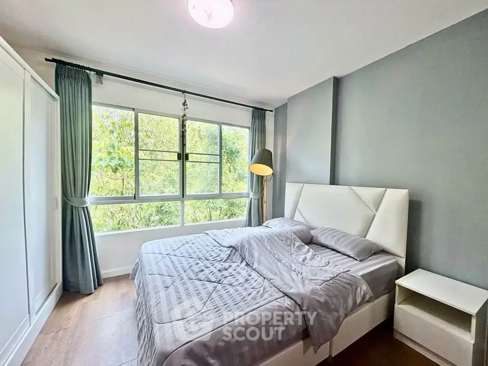 Bright and cozy bedroom with large window and modern decor
