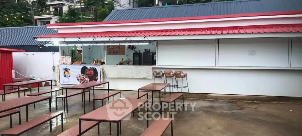 Charming outdoor food stall with seating in a vibrant urban setting.