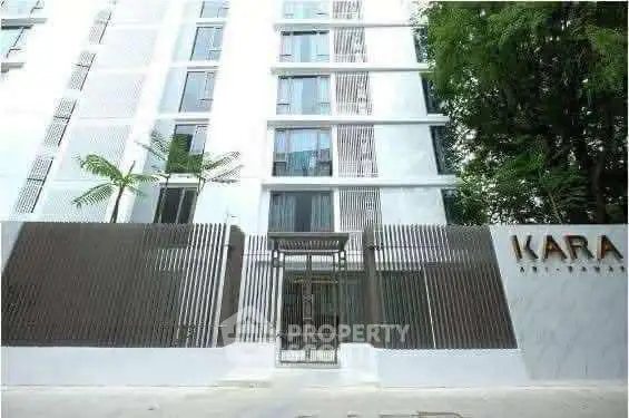 Modern apartment building exterior with sleek design and lush greenery.