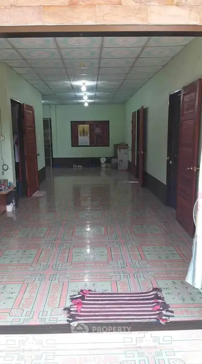 Spacious interior with tiled flooring and multiple wooden doors, ideal for versatile living arrangements.