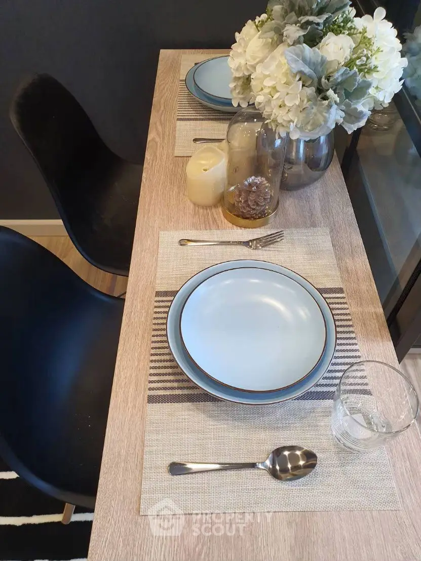 Stylish dining setup with elegant tableware and floral centerpiece in modern kitchen.