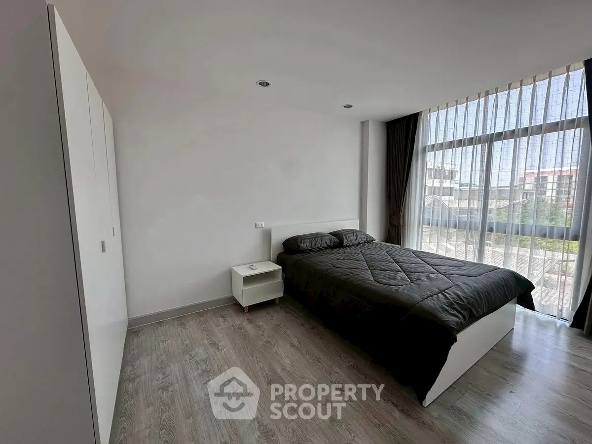 Modern bedroom with large window and sleek furnishings