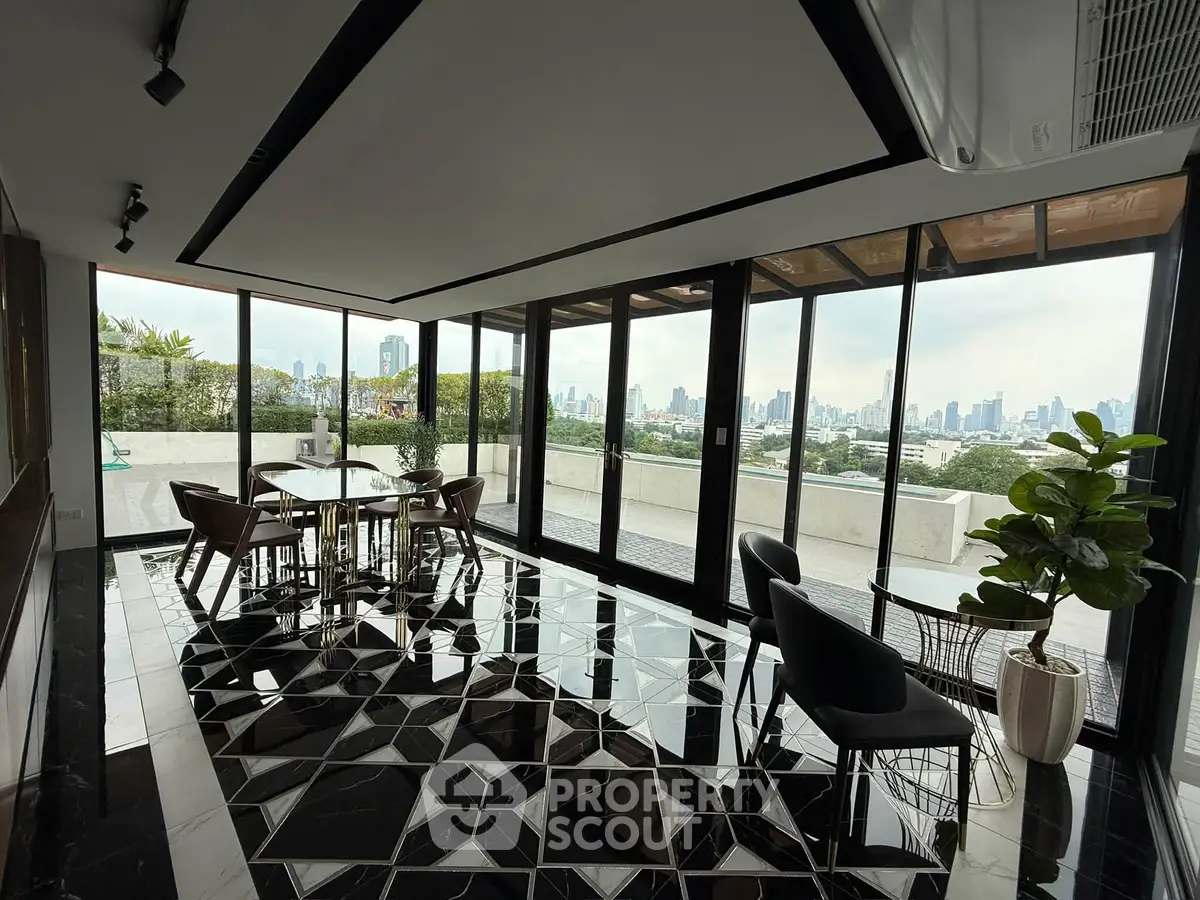 Luxurious modern living room with panoramic city views and stylish black and white flooring.
