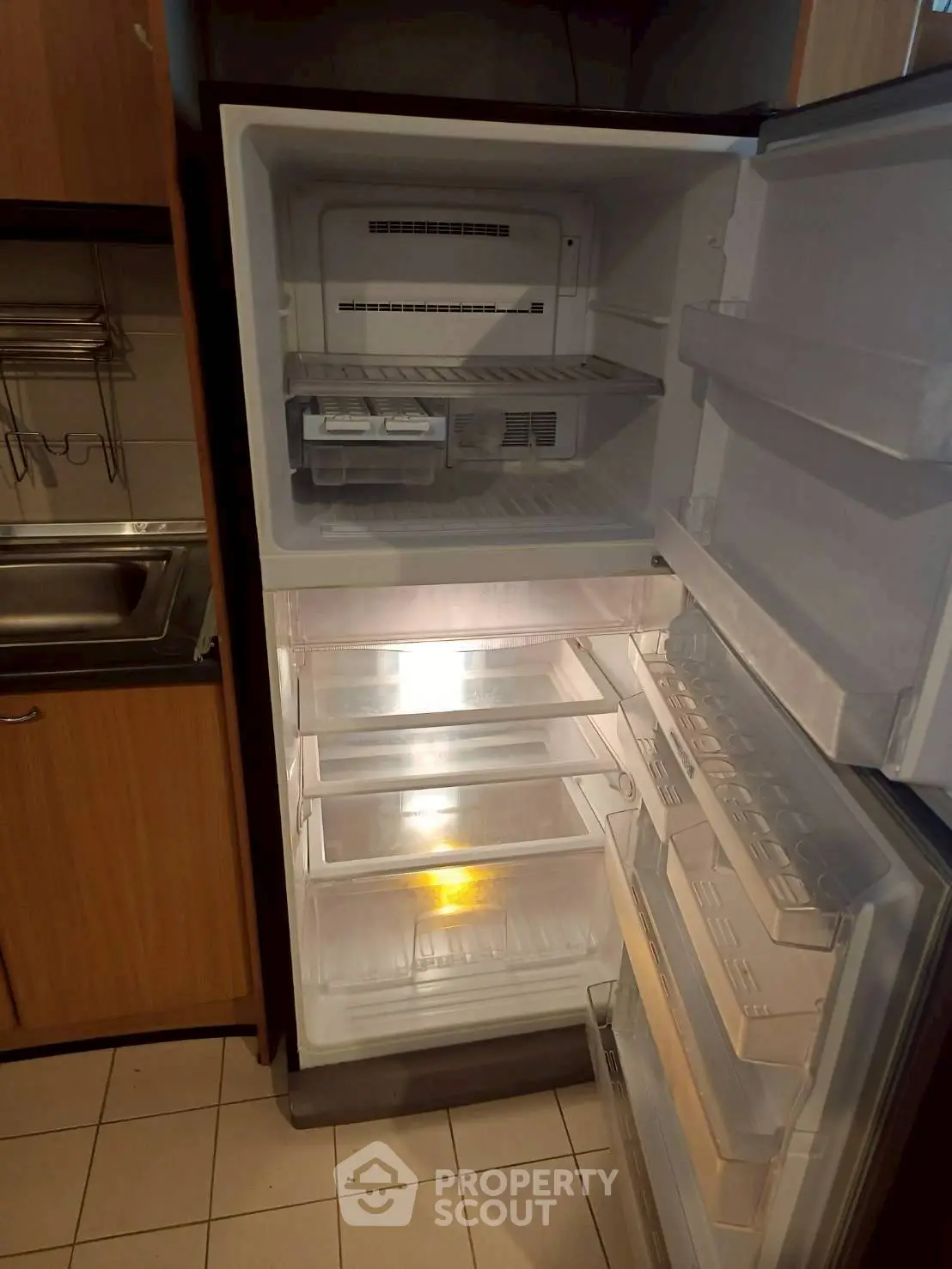 Spacious kitchen with modern refrigerator and ample storage space.