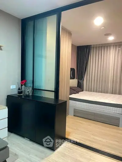 Modern bedroom with sliding glass door and stylish decor in a cozy apartment.