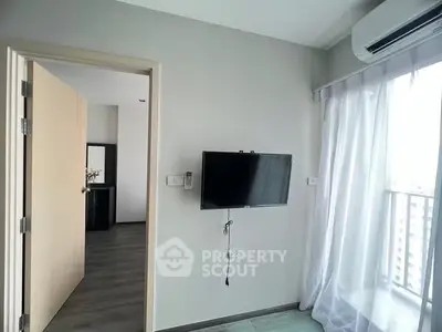 Modern apartment interior with wall-mounted TV and balcony view