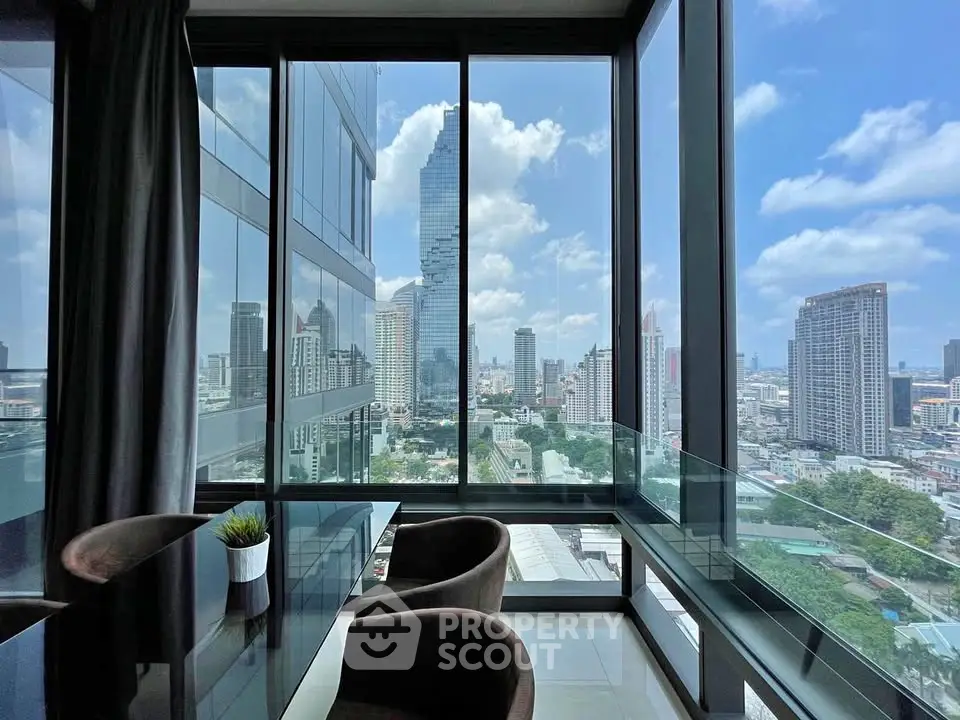 Stunning city view from modern high-rise apartment with floor-to-ceiling windows.