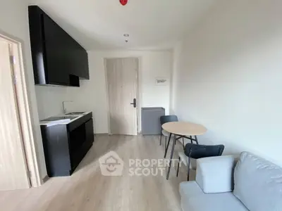 Modern studio apartment with sleek kitchen and cozy living area, perfect for urban living.