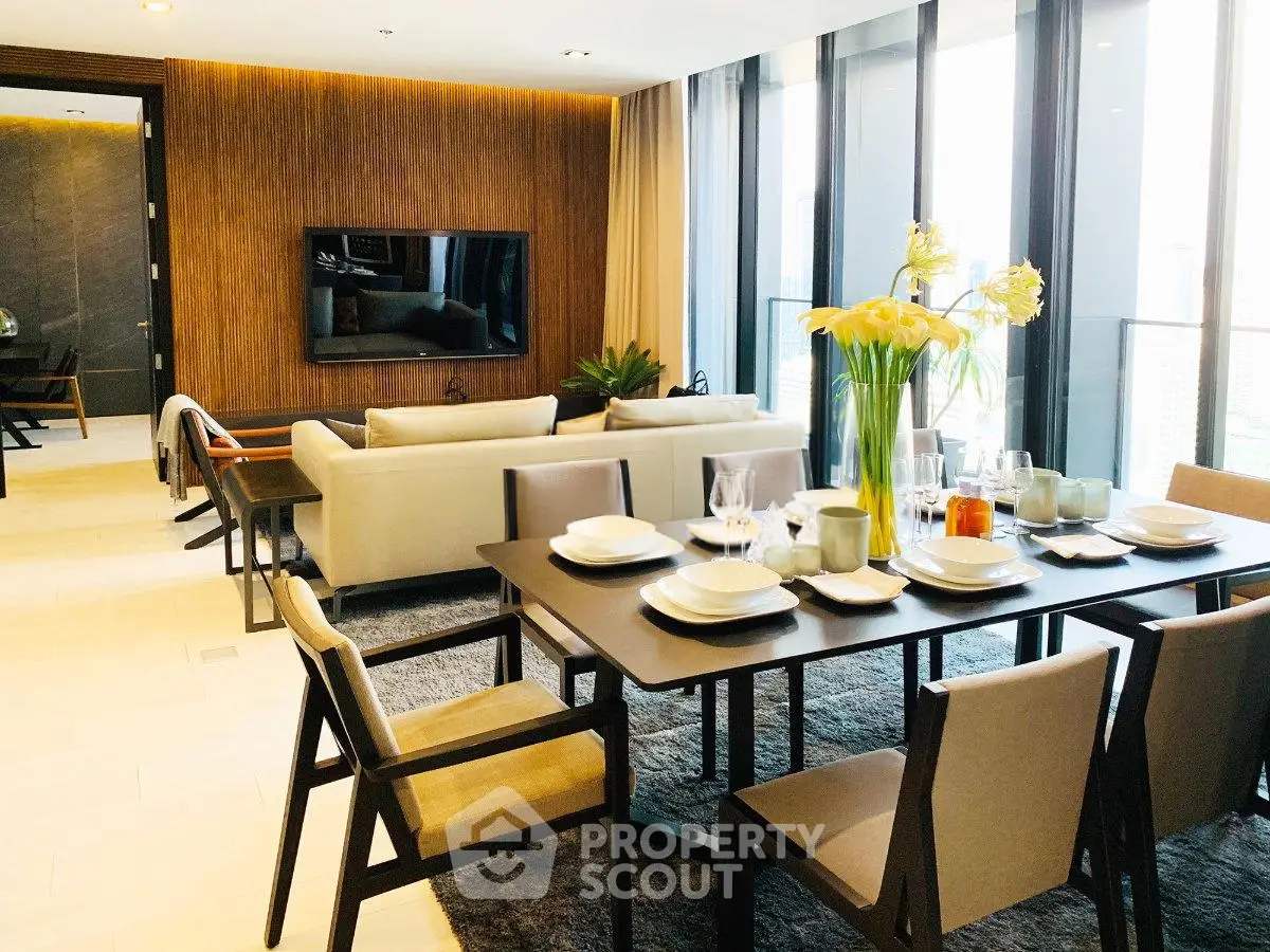 Luxurious open-plan living and dining area with elegant decor and floor-to-ceiling windows.