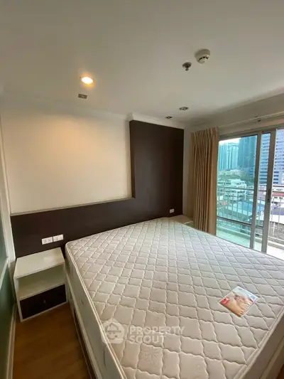 Spacious bedroom with large window and city view, featuring a comfortable bed and modern decor.