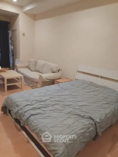 Cozy bedroom with a comfortable bed and a small sofa, perfect for relaxation.