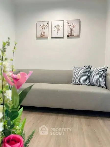 Stylish living room with modern sofa and floral decor, perfect for cozy relaxation.