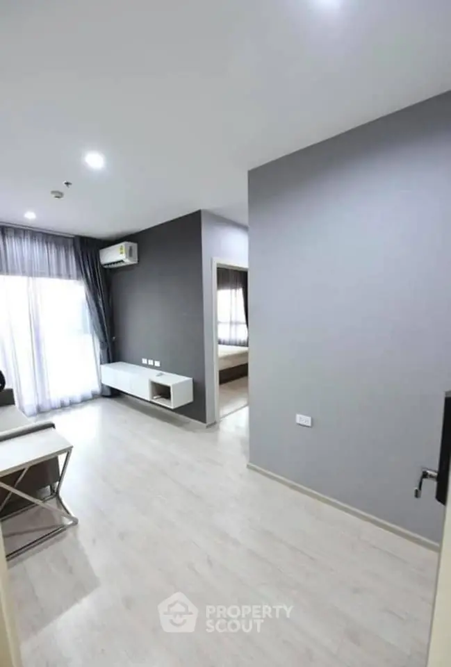 Modern apartment interior with sleek design and natural light, featuring a spacious living area and bedroom.