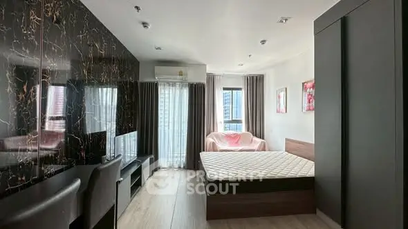 Modern bedroom with stylish decor and large window view in urban apartment.